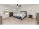 Bright bedroom with neutral carpet, ceiling fan, two windows, and classic furnishings including a dresser and nightstand at 4538 Opus Ln, Charlotte, NC 28214