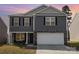 Charming two-story home with gray siding, stone accents, and a two-car garage for convenient parking at 4538 Opus Ln, Charlotte, NC 28214