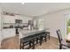 Bright kitchen features white cabinets, granite counters, stainless appliances and large island with breakfast bar seating at 4538 Opus Ln, Charlotte, NC 28214