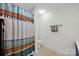 Cozy bathroom features tiled floors, bathtub with colorful curtain, and bright lighting at 4937 Broken Saddle Ln, Charlotte, NC 28226