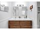 Bright bathroom featuring double sinks, modern lighting, and a sleek wood vanity at 4937 Broken Saddle Ln, Charlotte, NC 28226