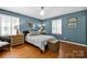 Charming bedroom featuring hardwood floors, a comfortable bed, and stylish decor elements at 4937 Broken Saddle Ln, Charlotte, NC 28226