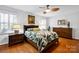 Light bedroom with a patterned bedspread, hardwood floors, and decorative lighting at 4937 Broken Saddle Ln, Charlotte, NC 28226