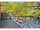 Outdoor deck area with a dining table and seating with views of the beautiful, wooded surroundings at 4937 Broken Saddle Ln, Charlotte, NC 28226