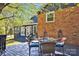 The outdoor deck features a dining table and seating, and is attached to the brick home at 4937 Broken Saddle Ln, Charlotte, NC 28226