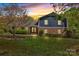 Charming two-story home with a brick facade and a well-manicured lawn during a vibrant sunset at 4937 Broken Saddle Ln, Charlotte, NC 28226
