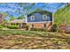 Traditional two-story home with a brick exterior, well-kept lawn and mature trees with shadows at 4937 Broken Saddle Ln, Charlotte, NC 28226