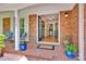 Inviting front porch with brick flooring, a 'welcome' mat, and colorful potted plants by the front door at 4937 Broken Saddle Ln, Charlotte, NC 28226