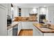 Well-lit kitchen featuring stainless steel appliances, granite countertops, custom cabinetry, and a butcher block island at 4937 Broken Saddle Ln, Charlotte, NC 28226
