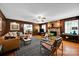 Cozy living room with wood paneling, stone fireplace, ceiling fan, and comfortable seating, great for relaxing or entertaining at 4937 Broken Saddle Ln, Charlotte, NC 28226