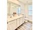 A bathroom featuring a double vanity, large mirror, and wood floors at 5861 Camp Sw Ct, Concord, NC 28025