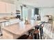 Kitchen island with seating that opens into a living area with a fireplace and sliding glass door at 5861 Camp Sw Ct, Concord, NC 28025