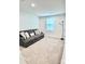 This cozy living room offers a comfortable gray couch with throw pillows and large light-filled window at 5861 Camp Sw Ct, Concord, NC 28025