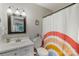 Bathroom with a rainbow curtain, single sink vanity, and a decorative mirror at 6605 Point Comfort Ln, Charlotte, NC 28226