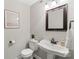 Elegant half bathroom with pedestal sink, framed mirror, and modern fixtures at 6605 Point Comfort Ln, Charlotte, NC 28226
