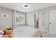 Bedroom with neutral walls, bright window, and view to an open bathroom with a pink toilet at 6605 Point Comfort Ln, Charlotte, NC 28226