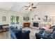 Bright living room features a vaulted ceiling, ceiling fan, and brick fireplace at 6605 Point Comfort Ln, Charlotte, NC 28226