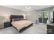Relaxing primary bedroom with a tufted headboard bed, ensuite balcony, and lamps at 6605 Point Comfort Ln, Charlotte, NC 28226