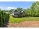 Expansive backyard with a well-maintained lawn, stone patio, and back exterior of home at 6743 Fox Ridge Cir, Davidson, NC 28036