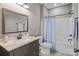 Bathroom with dark wood vanity, a large mirror, and shower and tub combo with a blue shower curtain at 6743 Fox Ridge Cir, Davidson, NC 28036