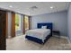 Bedroom features plush blue bed, neutral walls, and natural light through large windows and light colored floors at 6743 Fox Ridge Cir, Davidson, NC 28036