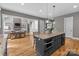 Modern kitchen featuring a large island with granite countertops, pendant lighting, and an open view of the living area at 6743 Fox Ridge Cir, Davidson, NC 28036