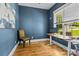 Bright office with hardwood floors, a standing desk, modern chair, and a large window overlooking greenery at 6743 Fox Ridge Cir, Davidson, NC 28036