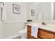 Cozy half bathroom featuring a wood vanity, a decorative mirror, neutral paint, and tile flooring at 8221 Pineville Matthews Rd # A, Charlotte, NC 28226