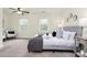 Well-lit bedroom with two windows, neutral carpet, a ceiling fan, and a beautifully dressed platform bed at 8221 Pineville Matthews Rd # A, Charlotte, NC 28226