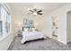 Bright bedroom features neutral carpet, walls, a ceiling fan, large windows, and access to the bathroom at 8221 Pineville Matthews Rd # A, Charlotte, NC 28226