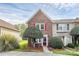 Charming brick townhome featuring a well-manicured front yard and inviting entrance with a red door and bright shutters at 8221 Pineville Matthews Rd # A, Charlotte, NC 28226