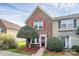 Charming brick townhome featuring a well-manicured front yard and inviting entrance with a red door and bright shutters at 8221 Pineville Matthews Rd # A, Charlotte, NC 28226