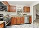 Well-maintained kitchen boasting stainless steel appliances, granite countertops, and ample wood cabinetry with tiled floors at 8221 Pineville Matthews Rd # A, Charlotte, NC 28226