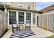 Outdoor patio featuring rocking chairs, a striped rug, and a view of the surrounding yard at 8221 Pineville Matthews Rd # A, Charlotte, NC 28226