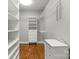 Walk-in closet with built-in shelving and wooden floors at 9008 Skipaway Dr, Waxhaw, NC 28173