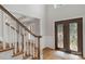 Elegant foyer features a wooden staircase, hardwood floors, and a decorative glass front door at 9008 Skipaway Dr, Waxhaw, NC 28173