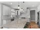 Modern white kitchen with granite countertops, stainless steel appliances, and a large center island with seating at 9008 Skipaway Dr, Waxhaw, NC 28173