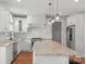 Bright white kitchen with granite counters, stainless steel appliances, and an island with bar stools at 9008 Skipaway Dr, Waxhaw, NC 28173