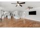 Bright open-concept living room featuring hardwood floors, modern lighting, and an adjacent kitchen at 9008 Skipaway Dr, Waxhaw, NC 28173