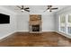 Bright living room featuring a stone fireplace, hardwood floors, and an open floor plan at 9008 Skipaway Dr, Waxhaw, NC 28173