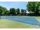 Community tennis court with green and blue surface, set among trees, and with black fencing at 9008 Skipaway Dr, Waxhaw, NC 28173