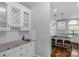 Modern wet bar with granite countertops, white cabinets, and stainless steel sink at 9008 Skipaway Dr, Waxhaw, NC 28173