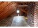 Unfinished attic with exposed wooden beams, brick chimney, and partial flooring waiting for renovation and conversion at 920 N Sixth St, Albemarle, NC 28001