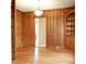 Dining room with wood-paneled walls, built-in shelving, hardwood floors, and elegant lighting fixture at 920 N Sixth St, Albemarle, NC 28001