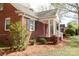 Charming brick home featuring a covered porch and neat landscaping on a sunny day at 920 N Sixth St, Albemarle, NC 28001