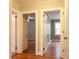 Hallway with hardwood floors and two open doors leading to bedrooms with neutral paint color and natural light at 920 N Sixth St, Albemarle, NC 28001