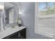 Cozy bathroom featuring a dark vanity, soft lighting, and a window bringing in natural light at 9319 Harps Mill Ct, Charlotte, NC 28270