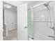Bathroom showcasing a shower/tub combo with glass doors, white subway tile, and a view to the hallway at 9319 Harps Mill Ct, Charlotte, NC 28270