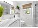 Stylish bathroom features a marble countertop, white cabinets, and a window with a woven shade at 9319 Harps Mill Ct, Charlotte, NC 28270