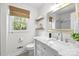 Bright bathroom features white walls, a window, a sink with a marble countertop, a toilet, and decorative shelves at 9319 Harps Mill Ct, Charlotte, NC 28270